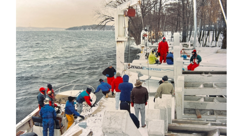 This photo shows the Melges 24, hull no. 1, being launched for the first time on Lake Geneva in the snow in December 1992